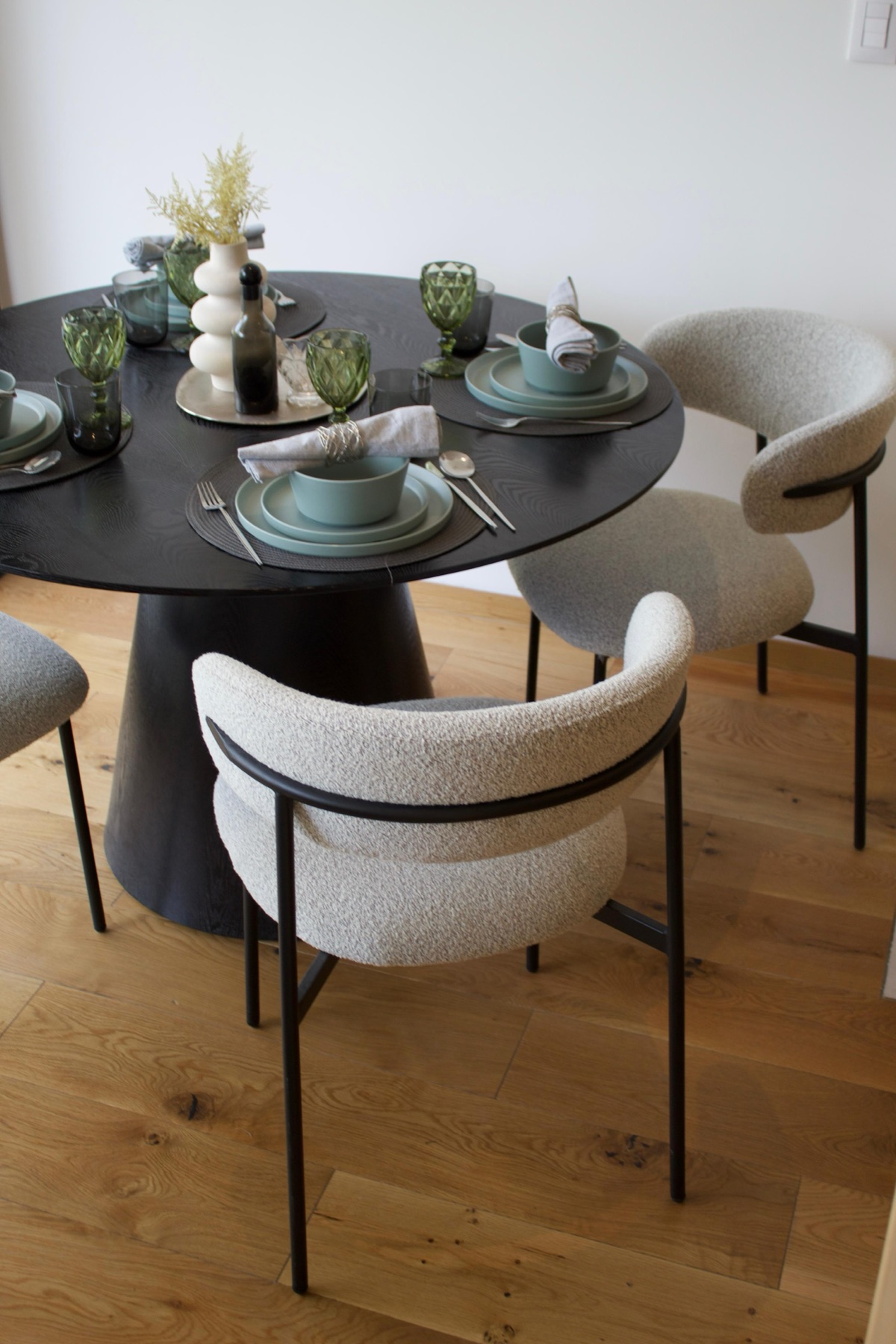 Comedor con mesa negra sobre piso de madera