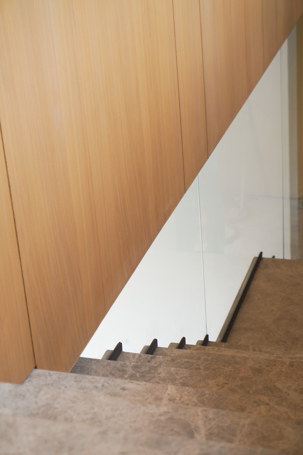 Detalle del descanso de la escalera con cristal y madera