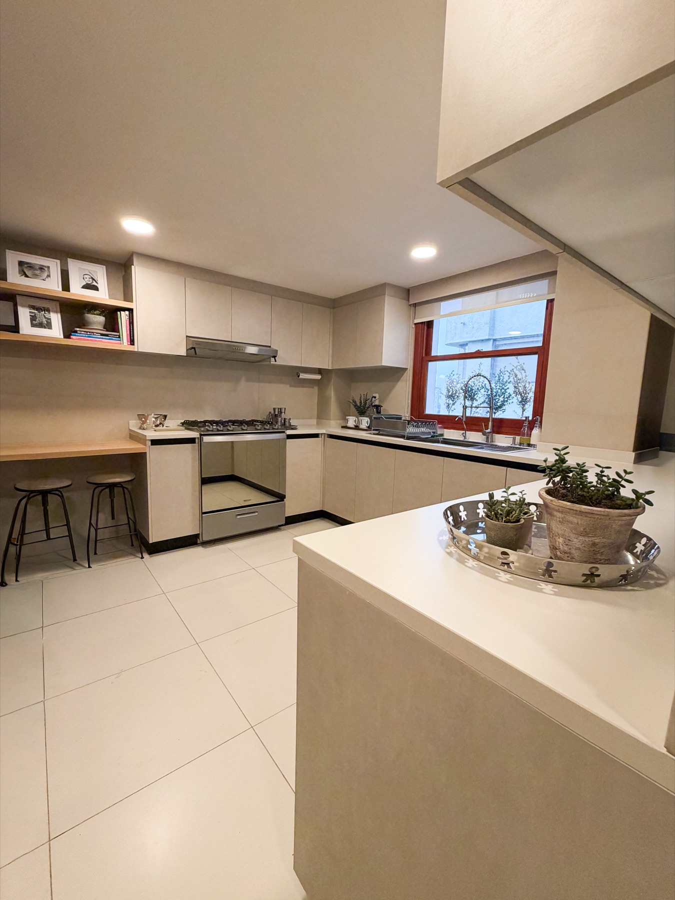 Cocina con cubierta blanca y ventana al patio