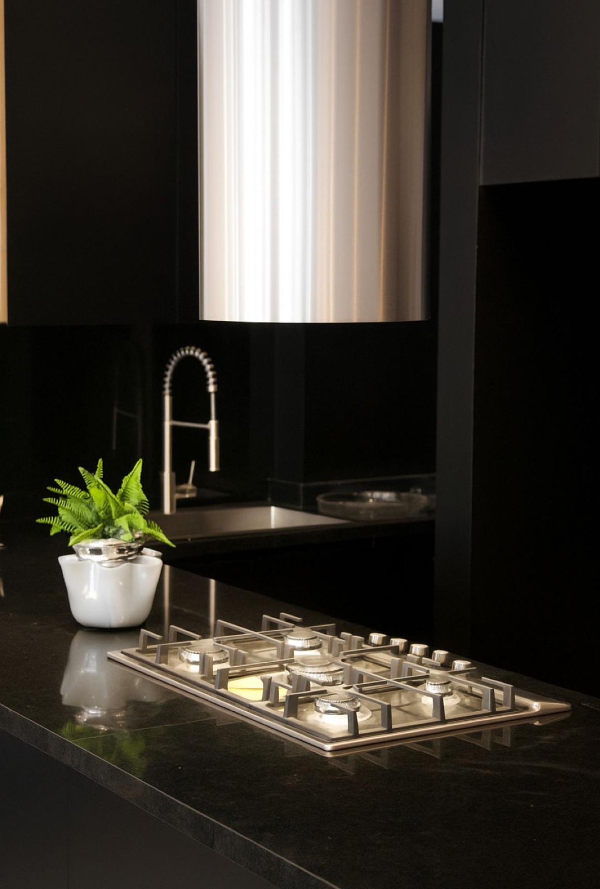 Cocina en negro con parrilla y campana en acero inoxidable